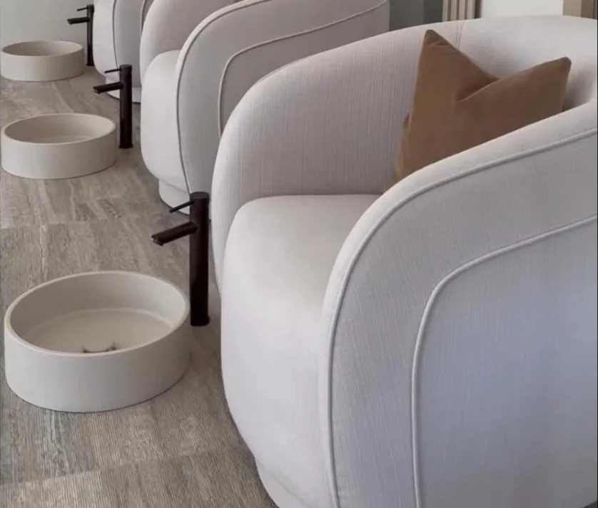 Curved pedicure chairs with stone foot bowls and black taps at ROH Day Spa