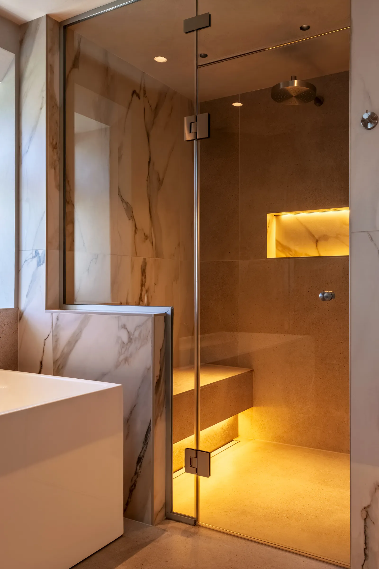 Arkendale master ensuite, glazed steam room with a lit niche and stone finishes