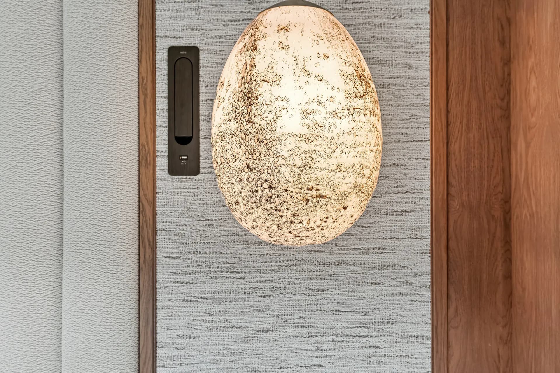 Ilkley Moor, alabaster wall light on a textured wall, lighting design by Dean Heim & Co.