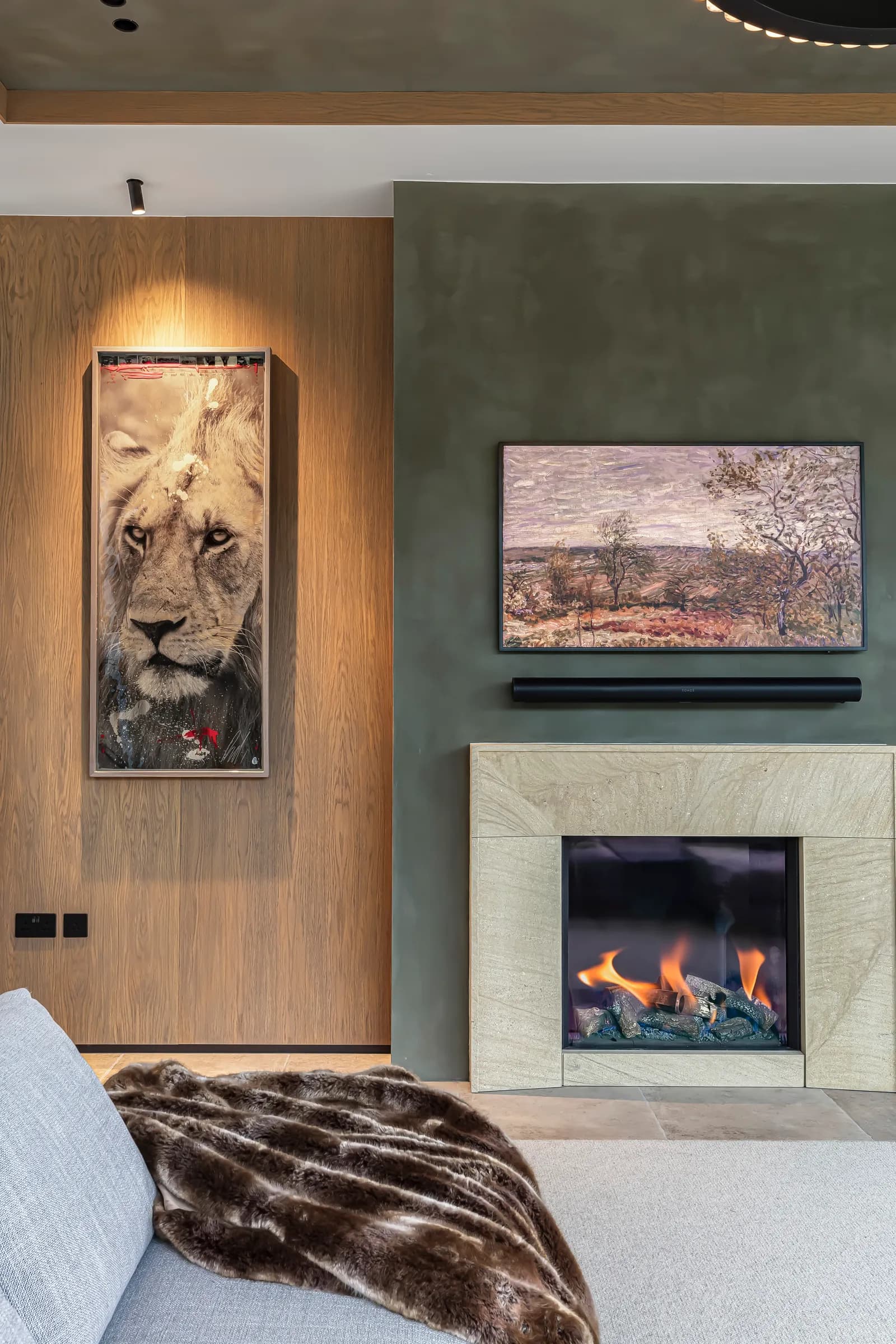 Art curation for interior design: a framed lion artwork and landscape piece above the fireplace, curated by Dean Heim & Co.