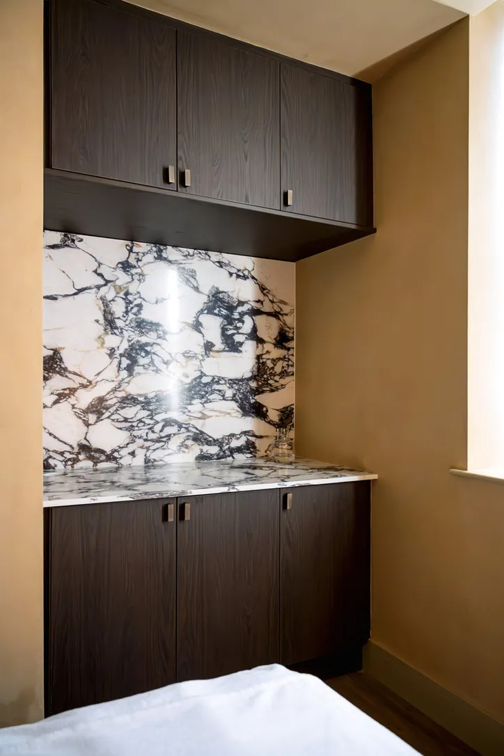 Marble splashback with dark made-to-order cabinetry, spa interior design Yorkshire