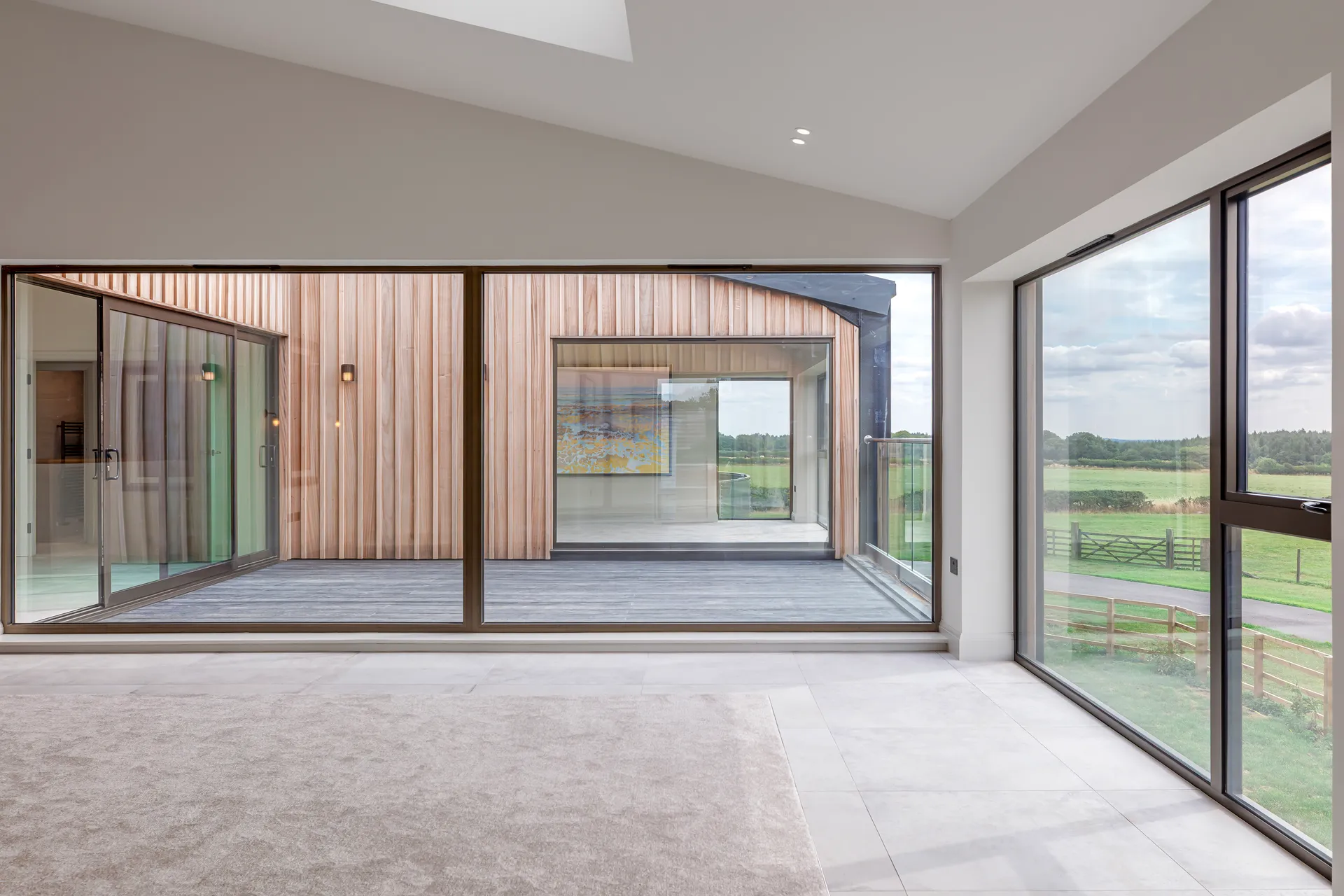 Home staging in Yorkshire: an open-plan living space with full-height glazing and countryside views at The Hay Barn, Spofforth, by Dean Heim & Co.