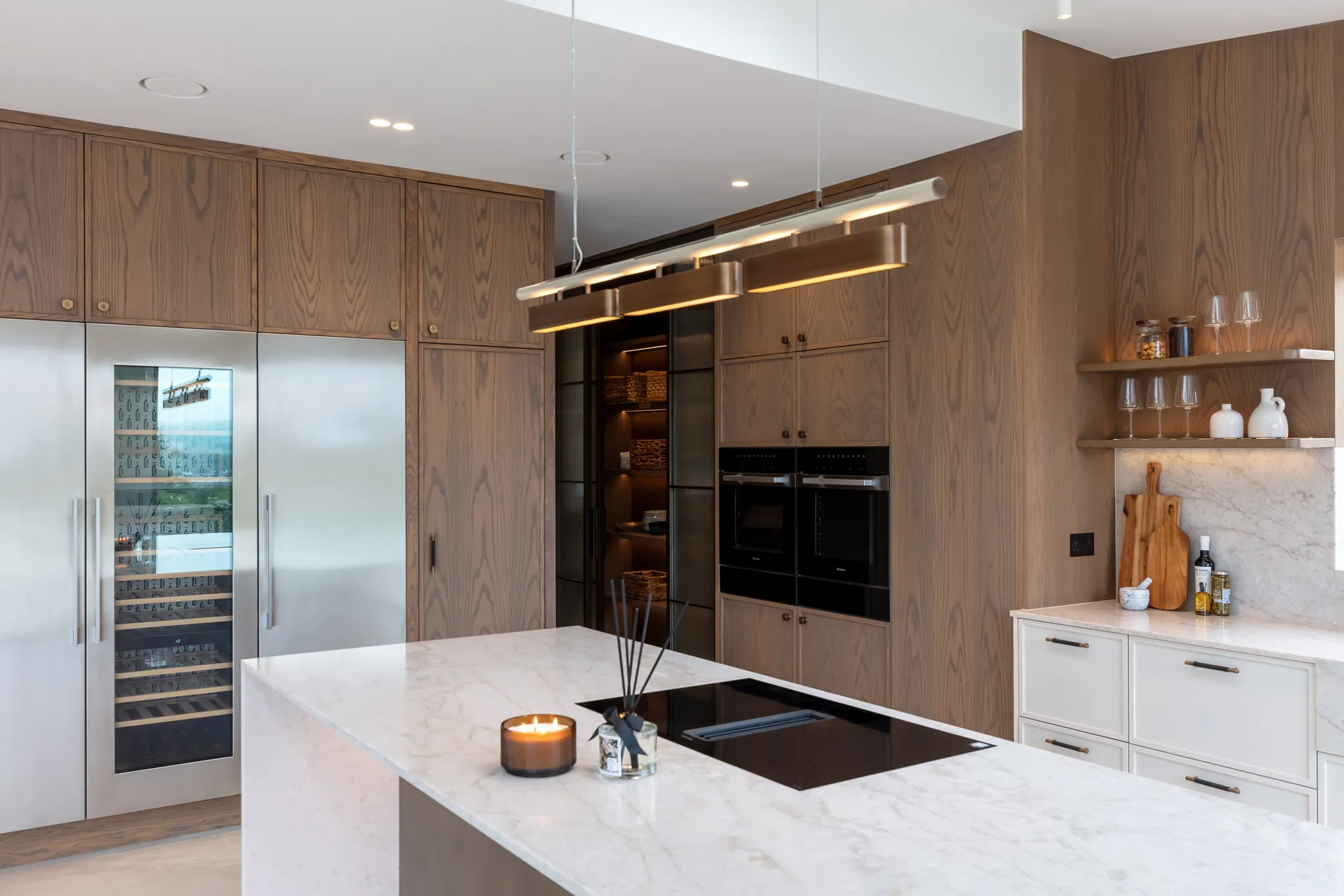 Interior design services in Yorkshire: an open-plan kitchen with oak cabinetry and a stone island at Elmtree Manor, by Dean Heim & Co.